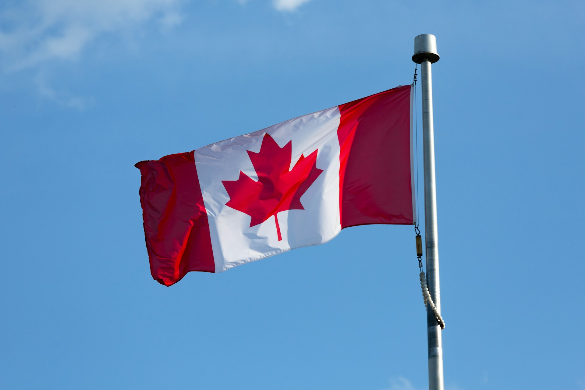 A canadian flag flying high in the sky